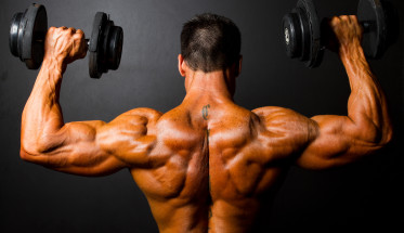 bodybuilder training with dumbbells