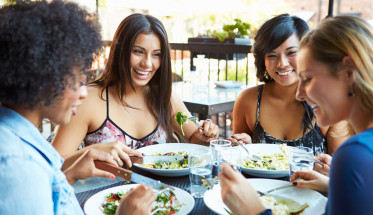 Group Of Female Friends Enjoying Meal At Outdoor Restaurant