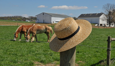 Amish hat on a farm fence post