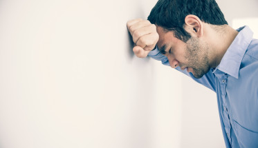 Man With Head Against Wall