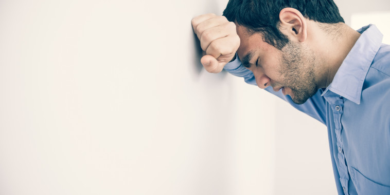 Man With Head Against Wall