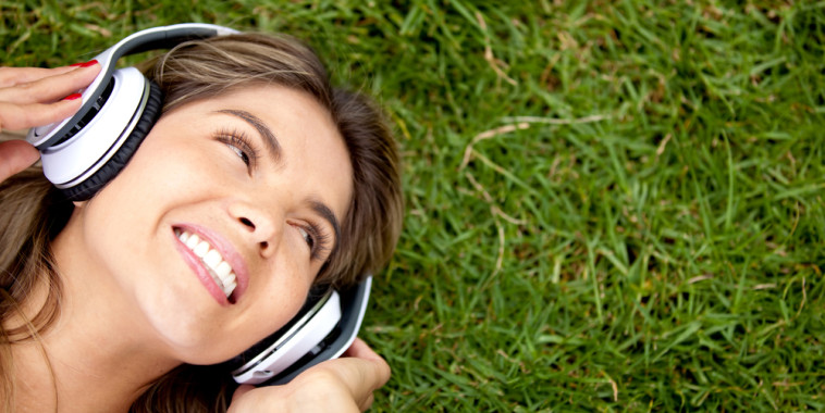 girl laying in grass with headphones