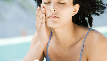 Girl applying sunscreen on beach