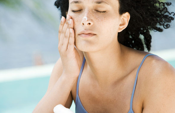 Girl applying sunscreen on beach