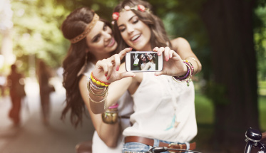 Hippie girls taking selfie at park