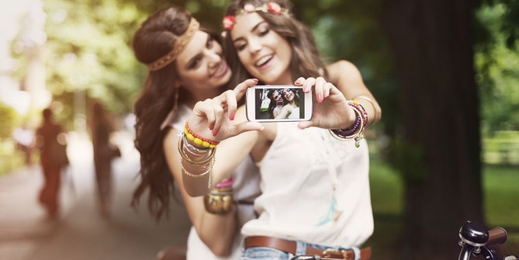 Hippie girls taking selfie at park